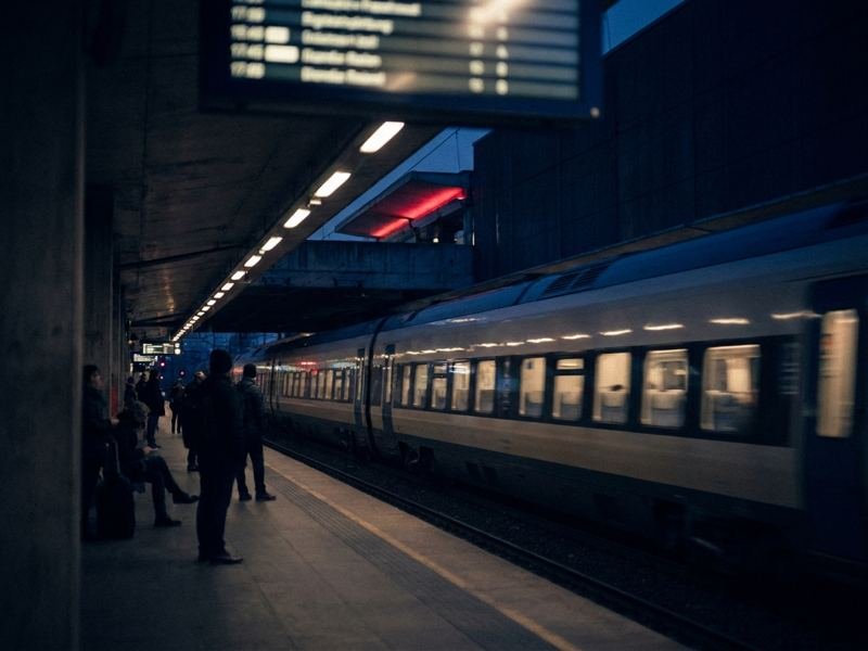 A passenger train arriving at a platform at dusk